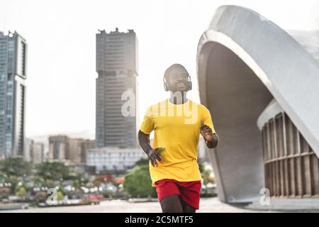 Junge schwarze Mann tun Workout-Routine am Morgen beim Laufen im Freien - Fit afrikanischen Läufer tun Cardio-Training, während Musik mit dem Kopf hören Stockfoto