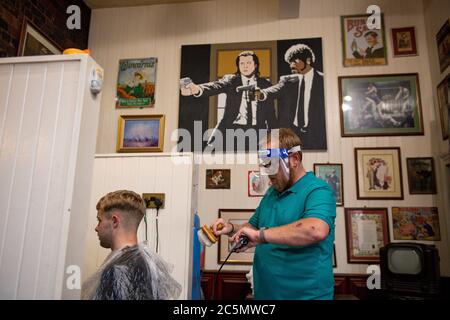 Die ersten Kunden bei der Wiedereröffnung von Jakes Barbers in Birmingham, da die Beschränkungen für die Coronavirus-Sperre in ganz England gelockert werden. Stockfoto
