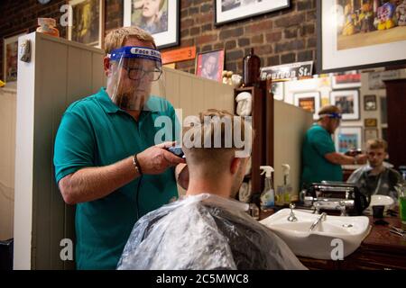 Die ersten Kunden bei der Wiedereröffnung von Jakes Barbers in Birmingham, da die Beschränkungen für die Coronavirus-Sperre in ganz England gelockert werden. Stockfoto