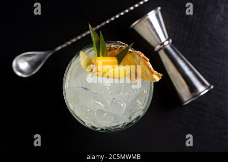 Cocktail mit tropischer Dekoration schwarzen Hintergrund von oben gesehen. Stockfoto