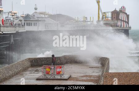 Brighton UK 4. Juli 2020 - Wellen brechen an einem nassen und windigen Tag an der Südküste am Brighton Palace Pier ein : Credit Simon Dack / Alamy Live News Stockfoto