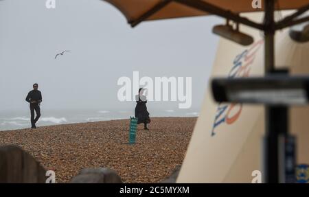 Brighton UK 4. Juli 2020 - Es ist ein nasser und windiger Tag für einen Spaziergang entlang Brighton Strand an der Südküste : Credit Simon Dack / Alamy Live News Stockfoto