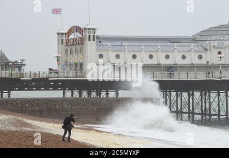 Brighton UK 4. Juli 2020 - Fotograf beobachtet, wie Wellen am Brighton Palace Pier an einem nassen und windigen Tag an der Südküste einstürzen : Credit Simon Dack / Alamy Live News Stockfoto