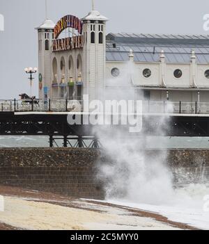 Brighton UK 4. Juli 2020 - Fotograf beobachtet, wie Wellen am Brighton Palace Pier an einem nassen und windigen Tag an der Südküste einstürzen : Credit Simon Dack / Alamy Live News Stockfoto