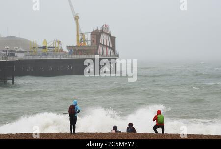 Brighton UK 4. Juli 2020 - Wellen brechen an einem nassen und windigen Tag an der Südküste am Brighton Palace Pier ein : Credit Simon Dack / Alamy Live News Stockfoto