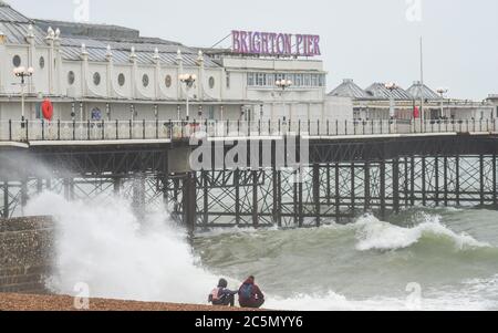 Brighton UK 4. Juli 2020 - Wellen brechen an einem nassen und windigen Tag an der Südküste am Brighton Palace Pier ein : Credit Simon Dack / Alamy Live News Stockfoto