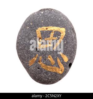 Chinesisches Zeichen xi oder japanisches Iki, was Ruhe bedeutet, geschrieben auf einem Kieselstein, isoliert auf weiß Stockfoto