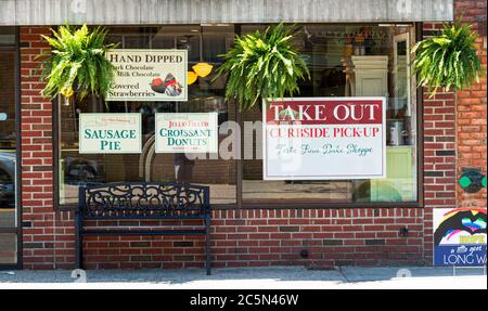 Schilder auf einer Bäckerei Fenster wegen der Coronavirus COVID-19 Pandemie liest nehmen nur und Bordwand pickup.in Babylon Village. Stockfoto