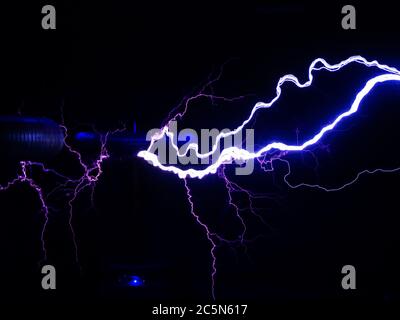 Elektrische Spulen strahlen im Dunkeln kraftvolle und helle Blitze ab Stockfoto
