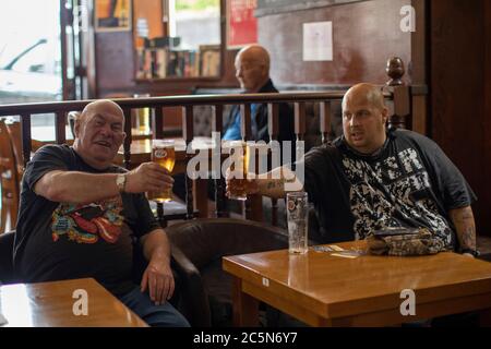 West Norwood, England. Juli 2020. Vater und Sohn genießen einen Drink in ihrem örtlichen Pub, der Horns Tavern in West Norwood, nach der Ankündigung der britischen Regierung, die Sperrregeln zu lockern. Pubs, Bars und Restaurants öffnen heute wieder, nachdem sie in Großbritannien wegen der Coronavirus-Pandemie für mehr als drei Monate geschlossen waren. (Foto von Sam Mellish / Alamy Live News) Stockfoto