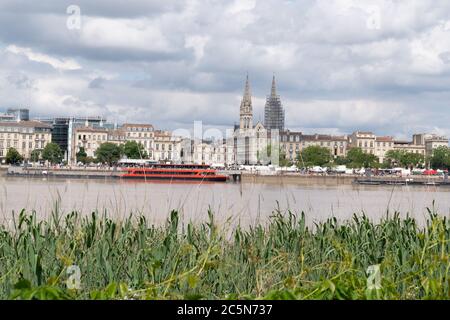 Bordeaux, Gironde / Frankreich - 05 26 2019 : Garonne Flussufer mit rotem Boot in Bordeaux Stadt, Frankreich Stockfoto