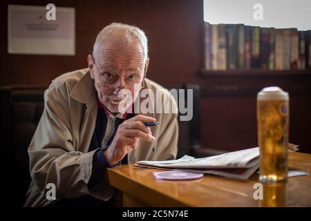 West Norwood, England. Juli 2020. Ein älterer Mann, der das Kreuzworträtsel in der Zeitung machte, während er in seinem örtlichen Pub, der Horns Tavern in West Norwood, ein Pint größer genoss, nachdem die britischen Regierungen angekündigt hatten, die Sperrregeln zu lockern. Pubs, Bars und Restaurants öffnen heute wieder, nachdem sie in Großbritannien wegen der Coronavirus-Pandemie für mehr als drei Monate geschlossen waren. (Foto von Sam Mellish / Alamy Live News) Stockfoto