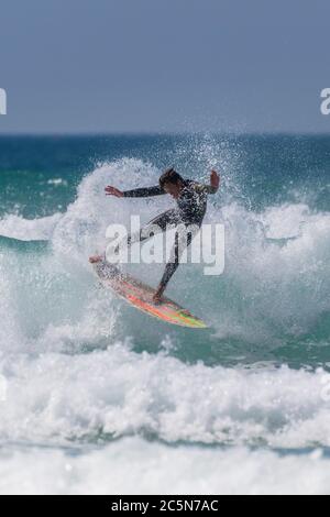 Spektakuläre Action, während ein junger Surfer eine Welle im Fistral in Newquay in Cornwall reitet. Stockfoto