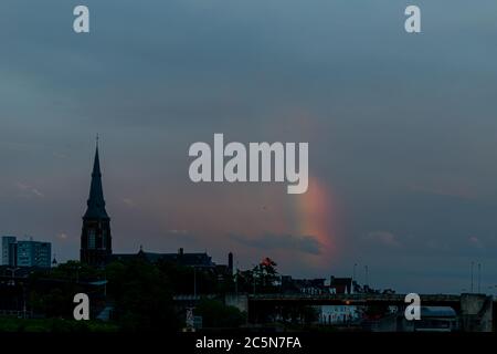 Skyline von Maastricht mit dem kommenden Gebiet Wyck und der Sint Servaas Brücke nach einem Sommerabend Sturm in der goldenen Stunde mit einem Regenbogen zeigen Stockfoto