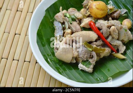 Würzig gekochtes Huhn und Eiersalat auf Bananenblatt auf dem Teller Stockfoto