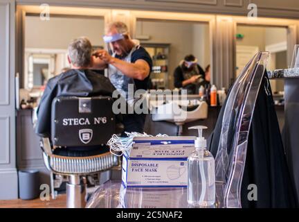 Harrogate, North Yorkshire, Großbritannien. Juli 2020. David Steca und Hugo Wragg vom Steca N.6 Friseurladen, bei der Arbeit mit voller PSA, während die Barbiere am Super Saturday wieder für die Öffentlichkeit geöffnet werden. Kredit: ernesto rogata/Alamy Live Nachrichten Stockfoto