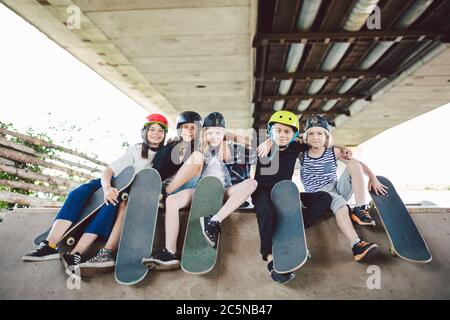 Extremsport in der Stadt. Skateboarding Club für Kinder. Gruppenfreunde posieren auf Rampe im Skatepark. Frühe Jugend im Skate-Training. Freunde Stockfoto