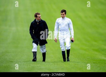 Jockey Ryan Moore (links) und William Buick gehen vor dem Beginn der Epsom-Rennen auf dem Kurs. Stockfoto