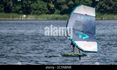 Berlin, Deutschland. Juli 2020. Ein Flügelsurfer reitet auf den Wellen des Tegeler See. Wing-Surfing bietet eine Kombination aus Windsurfen und Kiting. Quelle: Paul Zinken/dpa/Alamy Live News Stockfoto