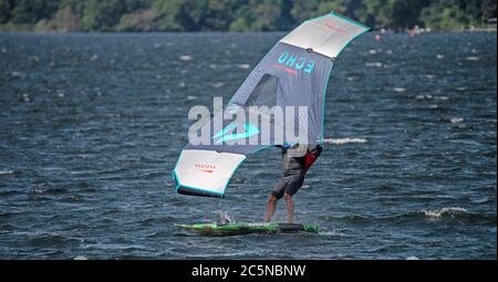 Berlin, Deutschland. Juli 2020. Ein Flügelsurfer reitet auf den Wellen des Tegeler See. Wing-Surfing bietet eine Kombination aus Windsurfen und Kiting. Quelle: Paul Zinken/dpa/Alamy Live News Stockfoto