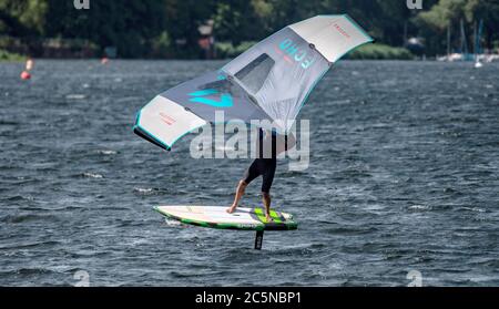 Berlin, Deutschland. Juli 2020. Ein Flügelsurfer reitet auf den Wellen des Tegeler See. Wing-Surfing bietet eine Kombination aus Windsurfen und Kiting. Quelle: Paul Zinken/dpa/Alamy Live News Stockfoto