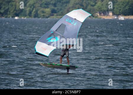 Berlin, Deutschland. Juli 2020. Ein Flügelsurfer reitet auf den Wellen des Tegeler See. Wing-Surfing bietet eine Kombination aus Windsurfen und Kiting. Quelle: Paul Zinken/dpa/Alamy Live News Stockfoto