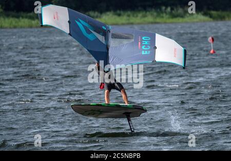 Berlin, Deutschland. Juli 2020. Ein Flügelsurfer reitet auf den Wellen des Tegeler See. Wing-Surfing bietet eine Kombination aus Windsurfen und Kiting. Quelle: Paul Zinken/dpa/Alamy Live News Stockfoto