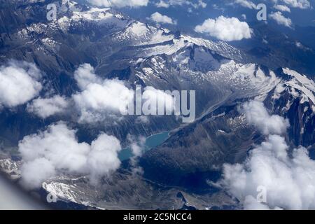 See von Österreich zwischen verschneiten Bergen. Schnee, See und Berge in Europa an einem bewölkten Tag, von einem Flugzeug aus gesehen. . Stockfoto