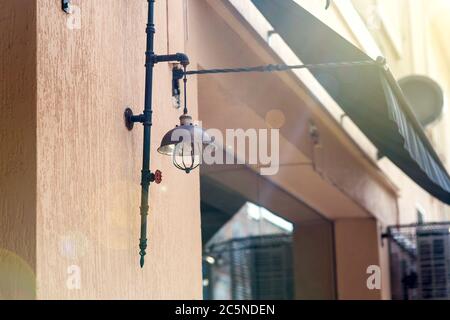 Straßenlaterne Beleuchtung in einem dunklen Farbe Loft-Stil an der Fassade eines Cafés mit einem Fenster und einem Visier für den Schatten von der Sonne mit einem Sonneneinbruch. Stockfoto