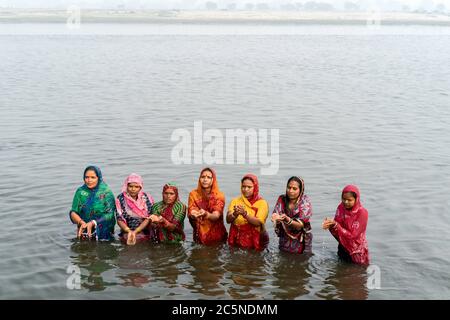 Hinduistische Frauen bieten nach einem rituellen Bad im heiligen Yamuna-Fluss in Vrindavan, Uttar Pradesh, Indien, Gebete an. Stockfoto