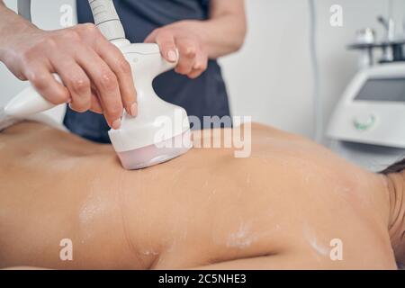 Rücken der jungen Frau während der Hautbehandlung Verfahren Stockfoto