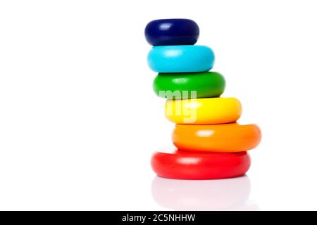 Eine große Pyramide aus farbigen Holzringen der Farbe lgbt Flagge isoliert auf einem weißen Hintergrund Kopie Raum. Stockfoto