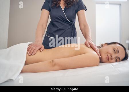 Glückliche Frau mit Massage ihres Körpers im Spa Salon Stockfoto