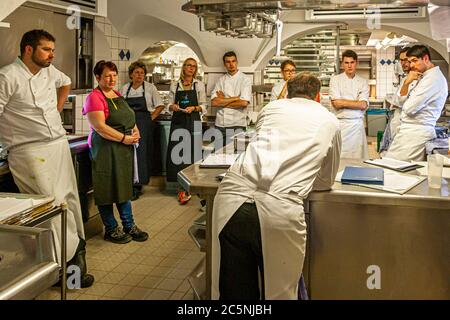 Michelin-Sterne-Koch Thomas Kellermann spricht mit seinem Küchenteam, darunter Sous-Chef Robert Morgan (links) und der Journalistin Angela Berg, in der Küche von Wernberg Castle, Wernberg-Köblitz, Oberpfalz, Deutschland. Stockfoto