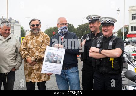 Brighton UK 4. Juli 2020 - Polizeibeamte beobachten, wie Mods sich an der Küste von Brighton versammeln, um sich für die Wiedereröffnung des Madeira Drive für den Verkehr zu werben. Die berühmte Straße, wo sie traditionell treffen die meisten Wochenenden wurde durch den stadtrat während der Coronavirus-Krise geschlossen, um soziale Distanzierung zu erleichtern, aber es gibt eine Möglichkeit, es dauerhaft geschlossen . Viele große Veranstaltungen, darunter der London to Brighton Car Run, finden jedes Jahr an der Strandstraße statt : Credit Simon Dack / Alamy Live News Stockfoto