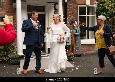 Tracie Kenny und Neal Arden verlassen ihre Hochzeitszeremonie im Best Western Valley Hotel, Ironbridge, da Hochzeiten in England wieder stattfinden dürfen, wobei die Festlichkeiten auf maximal 30 Gäste begrenzt sind. Stockfoto