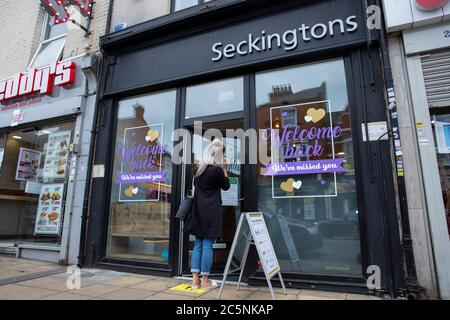 NORTHAMPTON, ENGLAND – 4. JULI: Eine Dame wartet vor Seckingtons Friseuren in Northampton auf soziale Disstanzierungsregeln, da Barbershops und Friseure in ganz England wieder geöffnet werden, nachdem sie seit März wegen der von der britischen Regierung verhängten Lockdown geschlossen wurde, um die Ausbreitung der COVID-19-Pandemie einzudämmen (Credit Leila Coker / MI News) Kredit: MI Nachrichten & Sport /Alamy Live News Stockfoto