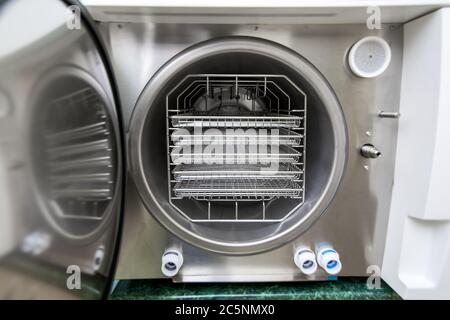 Autoklav Sterilisator zahnärztliche Instrument, Nahaufnahme im Gerät mit leeren Regalen. Stockfoto