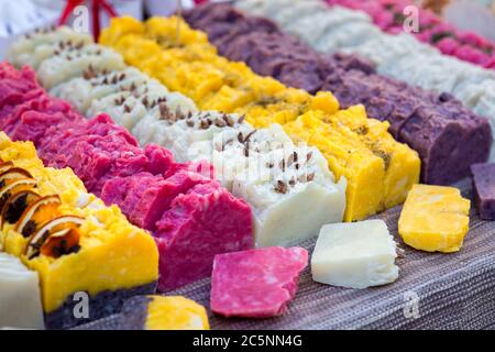 Handgemachte Seife auf der Theke des Ladens gelegt und in Stücke geschnitten, mehrfarbige Stücke Seife close up. Stockfoto