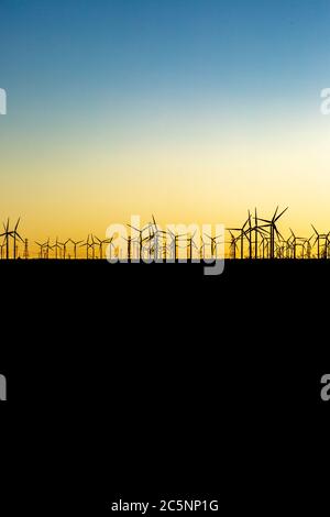 Silhouettierte Windturbinen gegen einen Sonnenuntergang Himmel, in Mojave, Kalifornien Stockfoto