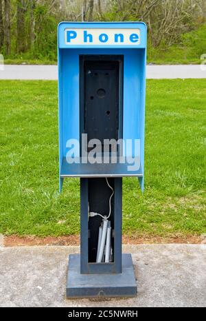 Eine alte abgebrochene Telefonzelle mit gebührenpflichtiger Telefonzelle auf einem Parkplatz, ohne das Telefon Stockfoto