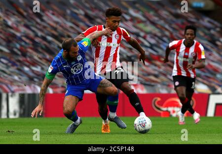 Wigan Athletic's Danny Fox (links) und Brentford's Ollie Watkins kämpfen während des Sky Bet Championship-Spiels im Griffin Park, London, um den Ball. Stockfoto