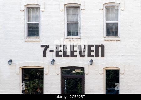 Washington, D.C. / USA - Juli 03 2020: Zeichen außerhalb eines Retro, Kolonialstil 7-Eleven. Weißes Ziegelreihenhaus mit einem einzigartigen schwarzen Schild. Stockfoto