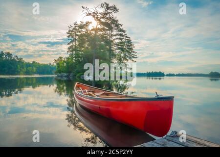 Kanu an einem Dock auf dem ruhigen Wasser des Stony Lake in den frühen Morgen gebunden, wenn es ruhig und gelassen ist, Stockfoto