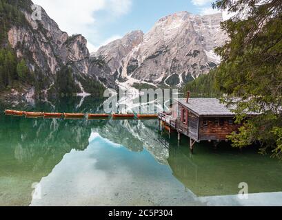 Hochwinkelansicht von ikonischem Bootshaus und Booten mit dem Seekofel-Berg, der sich im klaren, ruhigen Wasser des Pragser Wildsee (Pragser Pragser See) in den Dolomiten spiegelt, Stockfoto