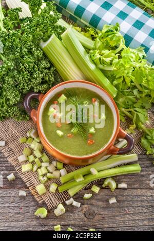 Potage Suppe aus frischen heimischen Sellerie mit Gewürzen. Reife süße gesunde Bio-Topfsuppe in einer Schüssel auf dem alten rustikalen Tisch. Stockfoto