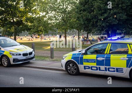 Polizeipräsenz während der Coronavirus-Sperre in einem Londoner Park an einem sonnigen Tag Stockfoto