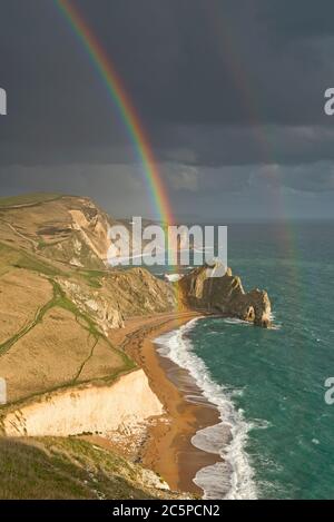 Ein doppelter Regenbogen über Durdle Door in Dorset an der Jurassic Coast. Teil der Dorset AONB und liegt auf der Route des South West Coast Path. Stockfoto