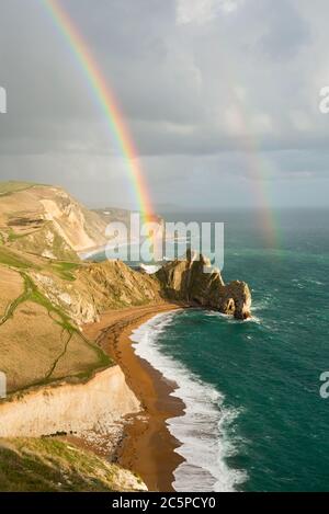 Ein doppelter Regenbogen über Durdle Door in Dorset an der Jurassic Coast. Teil der Dorset AONB und liegt auf der Route des South West Coast Path. Stockfoto