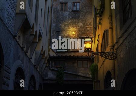 Beleuchtete Lampe in einer rustikalen Ecke in Florenz bei Nacht, Italien Stockfoto